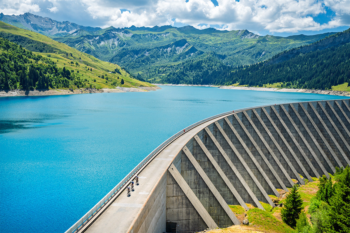 Cormet de Roseland Concrete dam with a blue lake and green mountains in the background