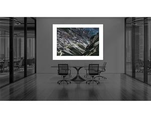 The Stelvio - Bormio Tunnels artwork displayed in a modern office setting, showcasing stunning cycling landscape photography.