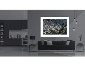 The Stelvio - Bormio Tunnels artwork displayed in a modern living room setting, showcasing cycling photography.